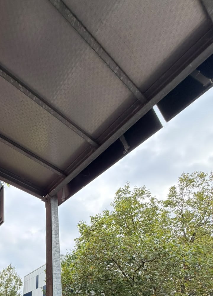 Decke und Eckpfosten aus Stahl an meinem hinteren Balkon, dahinter Bäume
