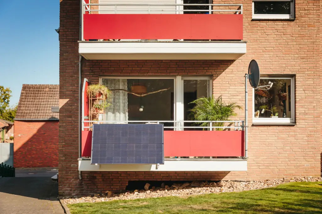 Balkone mit roter Verkleidung an einem Backsteinhaus