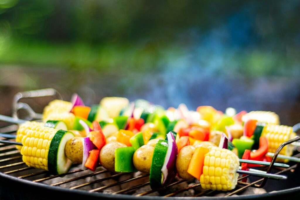 Gemüsespieße und Maiskolben auf einem Grillrost